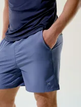 Bermuda deportiva azul con bolsillos laterales y logo pequeño en la pierna izquierda.