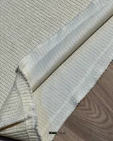 Buzo color crema de lana premium con textura acanalada y costuras expuestas.