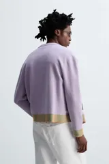 Cárdigan lila con diseño floral, cuello redondo, manga larga, rib en puños y ruedo, y cierre frontal con botones.