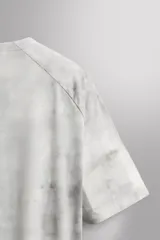 Camiseta de entrenamiento regular fit de Zara Athleticz, confeccionada en tejido técnico ligero y elástico con tecnología Quick Dry nivel 2. Presenta un estampado tipo tie-dye en tonos grises y blancos, cuello redondo, manga corta, costuras planas y termofijadas, y logo estampado en el bajo.