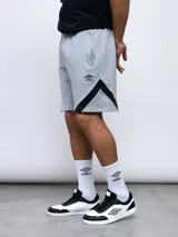 Bermuda deportiva negra de algodón y poliéster, con cintura elástica ajustable con cordón, bolsillos laterales y detalle de recortes geométricos en gris en los laterales. Logo de la marca bordado en la pierna izquierda.