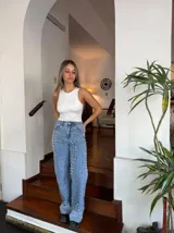 Pantalón de jean celeste de corte recto con tachas plateadas.