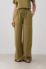 Pantalón verde oliva de corte palazzo con pretina elastizada y cordón ajustable. Incluye bolsillos laterales.