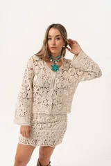 Saco color crudo de crochet con botones y mangas largas.