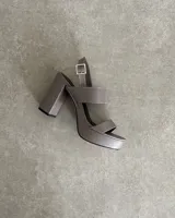 Sandalias negras de cuero sintético con plataforma y tacón cuadrado. Tienen dos tiras anchas sobre el empeine y una tira con hebilla alrededor del tobillo.