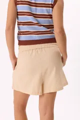 Short color beige de tela liviana, con cintura elastizada y lazo ajustable.