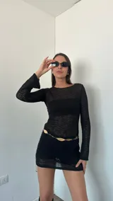 Minivestido blanco de tejido calado, con mangas largas acampanadas y diseño ajustado.