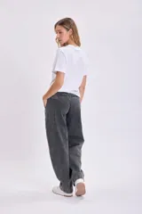 Pantalón de jean negro de corte carrot, tiro alto y pierna ancha.