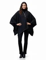 Ruana negra de tejido suave, con borde ribeteado en eco cuero y cierre frontal con botones metálicos dorados.