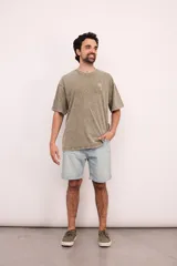 Remera color verde oliva con estampa pequeña de una palmera en el pecho, corte amplio y mangas cortas. Estilo casual.