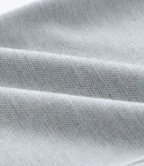 Pantalón de vestir gris con textura, corte slim, con trabillas en la cintura y cierre por botón y cremallera.