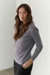 Sweater de punto marrón con escote en V y mangas largas.