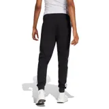 Pantalón de jogging Adidas Essentials para mujer, color negro, con cintura ajustable con cordón y puños elásticos en los tobillos. Presenta el logo de Adidas en blanco en la pierna izquierda.