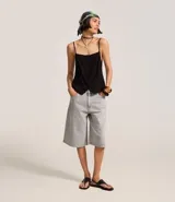 Bermuda femenina confeccionada en jeans color gris oscuro, modelo jorts, con trabillas en la cintura y bolsillos.