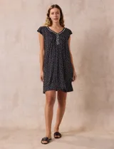 Camisón corto negro con estampado de lunares blancos, escote en V con puntilla blanca y botones.