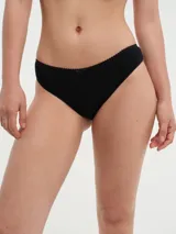 Bombacha de bikini color rosa claro, corte clásico con cintura baja y detalle de puntilla en el borde superior y moño pequeño en el centro.