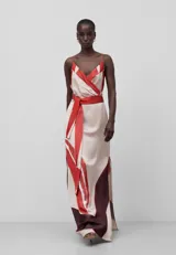 Vestido largo con estampado abstracto en tonos beige y rojo, de tirantes finos, escote pico cruzado, espalda descubierta, cinturón y drapeado en el delantero.