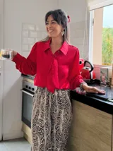 Camisa roja de mangas largas con lazo en el cuello y puños abotonados.