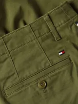 Bermuda cargo Tommy Hilfiger de color verde militar, con corte amplio y pierna recta. Confeccionada en sarga de algodón elástico, con dos bolsillos ribeteados en la cintura, dos bolsillos laterales tipo cargo y un bolsillo trasero de ojal con botón. Logo de Tommy Hilfiger bordado en la parte trasera.