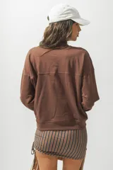 Buzo rojo de cuello alto con la palabra 'Rotunda' bordada en el frente. De corte holgado y mangas largas.