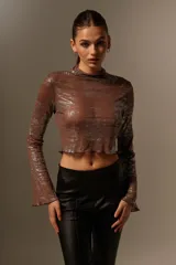 Blusa marrón con brillos plateados, cuello alto y mangas largas acampanadas.
