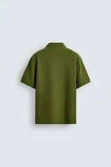 Polo verde oliva de tejido piqué, corte regular fit, cuello solapa con cierre frontal de botonadura y manga corta.