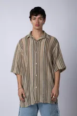 Camisa de manga corta con cuello solapa, corte holgado y estampado de rayas verticales en tonos beige, negro y rojo.