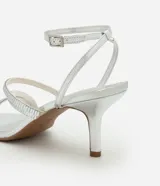 Sandalias plateadas de tacón fino, con punta cuadrada y tiras finas con apliques brillantes. Incluye tira con hebilla alrededor del tobillo.