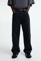 Pantalón de jean negro de corte holgado, con tiro bajo y cinco bolsillos.
