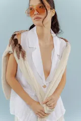 Chaleco color amarillo pastel de lino, sin mangas, con cuello solapa y cierre frontal con dos botones.