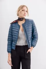 Campera corta negra de nylon rellena con pluma, corte holgado, cuello redondo y bolsillos con cierre.