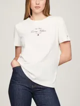 Remera blanca de algodón con cuello redondo y corte regular. Estampado frontal con el logo de Tommy Hilfiger en color rojo.