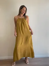 Vestido largo de lino color crudo, con escote halter fruncido y abertura lateral en la falda.