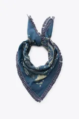 Pañuelo cuadrado azul con estampado de cachemir en tonos verde y blanco. Tiene flecos de cordón en los bordes.