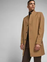 Abrigo tipo trench color camel con cierre frontal de botones y puños abotonados. Confeccionado en tejido pesado y funcionalidad a prueba de viento.