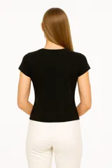 Blusa blanca de algodón con cuello a la base y mangas cortas.