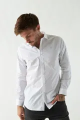 Camisa de vestir azul marino, de corte slim fit, manga larga y cuello clásico. Confeccionada en algodón y con logo bordado en el pecho.