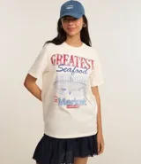 Remera t-shirt de algodón color crema, con cuello redondo y mangas cortas. Estampa frontal con la frase "Greatest Seafood" y un dibujo de un pez.