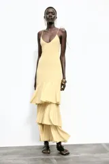 Vestido midi amarillo pálido con tirantes finos ajustables y escote en pico. Falda con tres volantes en capas.
