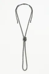Collar largo de cordón trenzado color negro con arandelas color peltre y nudo decorativo.