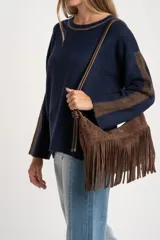 Sweater de punto azul marino con calce oversize. Presenta un detalle de franja vertical color marrón en la parte exterior de ambas mangas y un ribete fino dorado en el escote redondo.