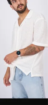 Camisa blanca de tejido crochet con cuello clásico y mangas cortas.