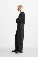 Sweater negro de punto con estructura de canalé, corte relaxed fit, cuello redondo y cierre de botones en el hombro.