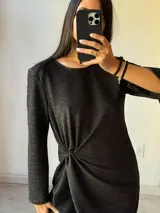 Minivestido negro brillante con mangas largas y nudo en la cintura.