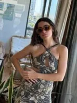 Vestido corto de lentejuelas color verde oliva, con escote en V, breteles finos cruzados en la espalda, cut-outs laterales y volado en el ruedo.