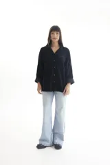 Camisa de pana color borgoña, de corte oversize, con cuello clásico, cierre frontal con botones, dos bolsillos con solapa en el pecho y mangas largas con puños abotonados.