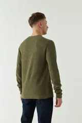 Sweater azul de punto con cuello redondo, mangas largas y logo bordado en el pecho. Corte slim fit.