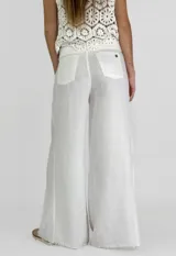 Pantalón de lino color ladrillo, de corte palazzo y tiro alto, con bolsillos laterales y cordón ajustable en la cintura.