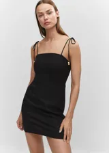Vestido corto negro de lino con tirantes finos ajustables con lazada y detalle de abalorios.