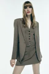 Blazer de cuello solapa y manga larga con estampado de pata de gallo en tonos marrones y negros. Bolsillos de vivo en delantero, detalle de coderas a contraste y cierre frontal con botón.